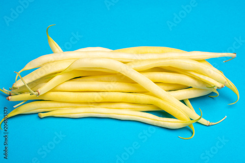Food concept with fresh legumes, ripe yellow butter beans copy space close up isolated on blue background
