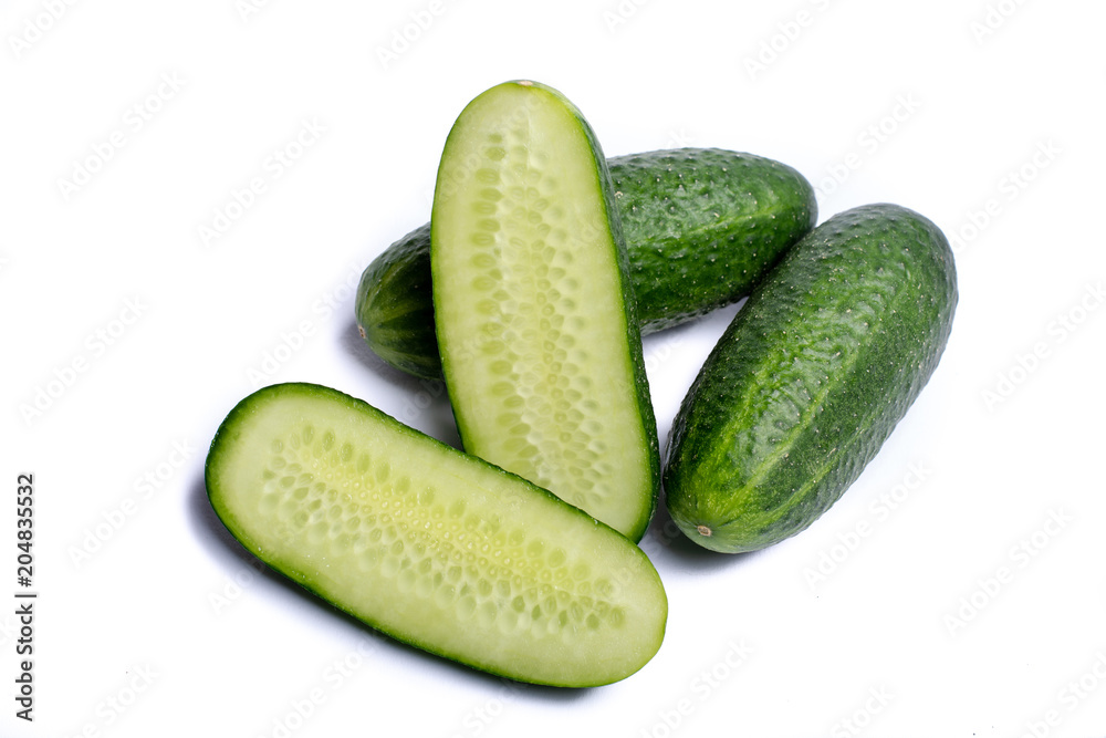 Fresh small green cucumbers whole and sliced close up copy space isolated on white background Fresh small green cucumbers whole and sliced close up copy space isolated on white background