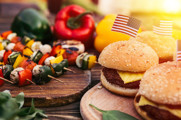 Burgers with us flags cooked outdoors on grill