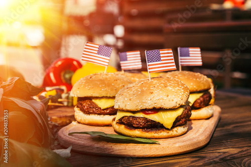 фотографія USA flags on hamburgers grilled for outdoors barbecue