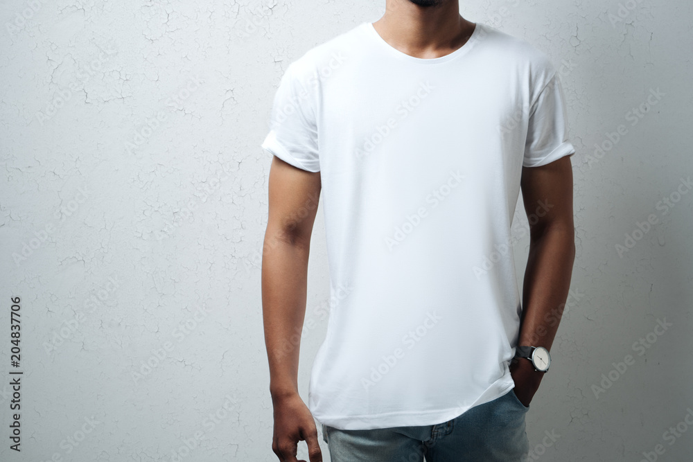 Guy wearing white blank t-shirt, grunge wall, horizontal studio close-up - obrazy, fototapety, plakaty 