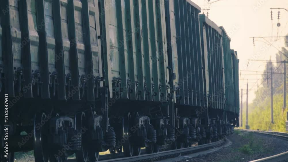 Freight train with cargo containers travelling in the industrial area 