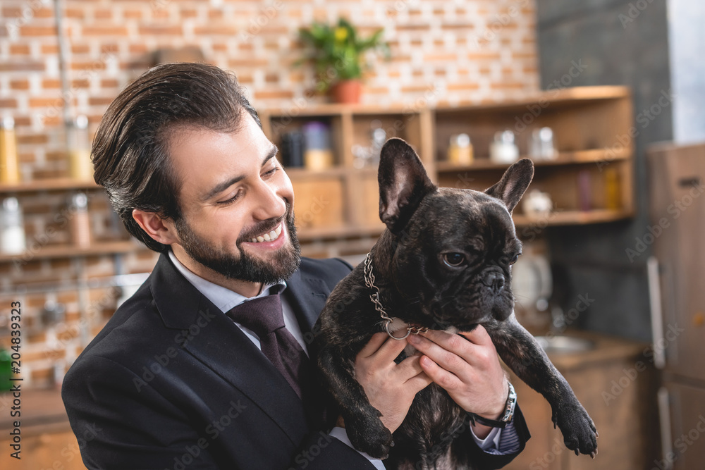 smiling handsome loner businessman hugging bulldog at kitchen smiling handsome loner businessman hugging bulldog at kitchen