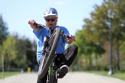 Man doing a wheelie on a bicycle.