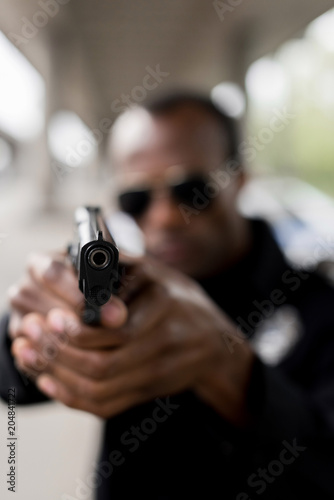 closeup view of black pistol in hands of policeman