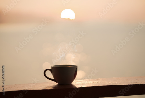 cup of coffee with sunset or sunrise background