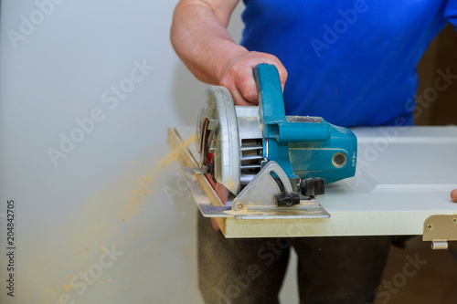 man using a circular saw for cutting wood door construction and home renovation, repair tool