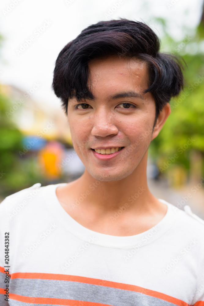 Young handsome Asian man in the streets outdoors Young handsome Asian man in the streets outdoors