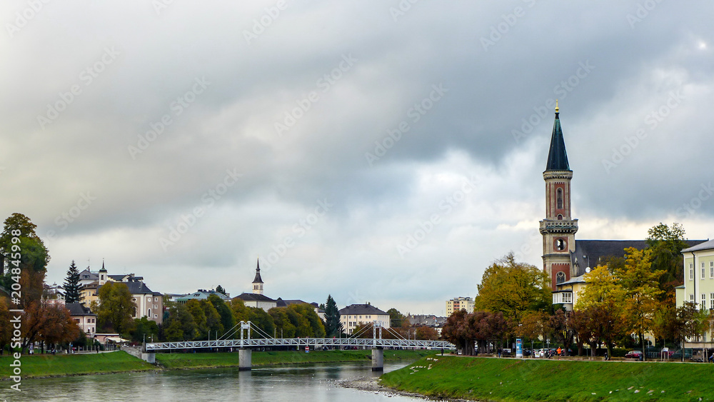 Obraz premium view of the bridge over the river with the church near the park