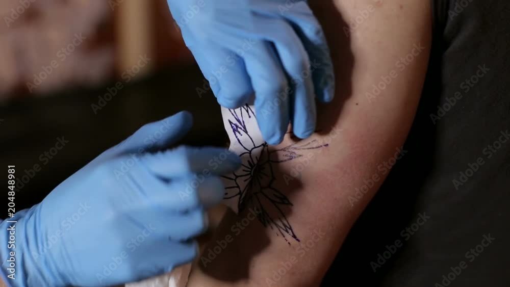 Tattoo artist puts a picture on the hand of a man, the process of creating a tattoo. Man doing picture on hand of man. Tattooist makes a tattoo. Close-up. Tattoo artist puts a picture on the hand of a man, the process of creating a tattoo. Man doing picture on hand of man. Tattooist makes a tattoo. Close-up.