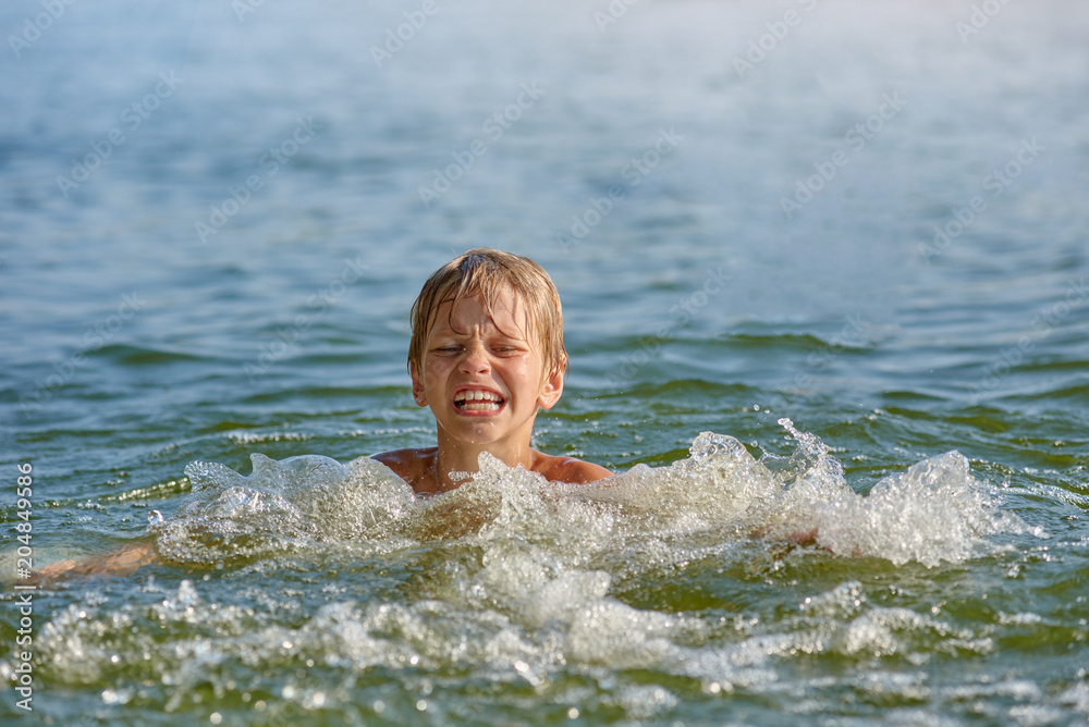 Happy little boy swimming in the river on summer weekend Happy little boy swimming in the river on summer weekend