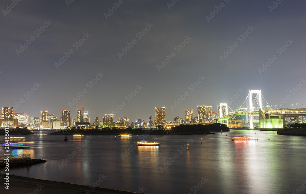東京都市景観　お台場からの夜景。ライトアップしたレインボーブリッジと屋形船
