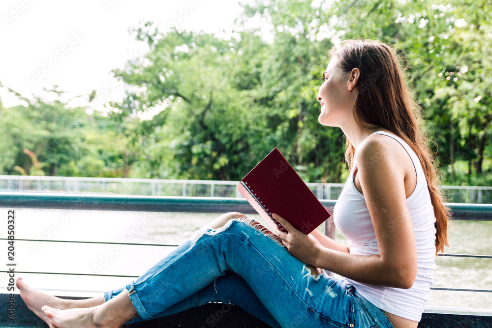 Obraz premium Woman students reading notebooks outdoors.Education concept