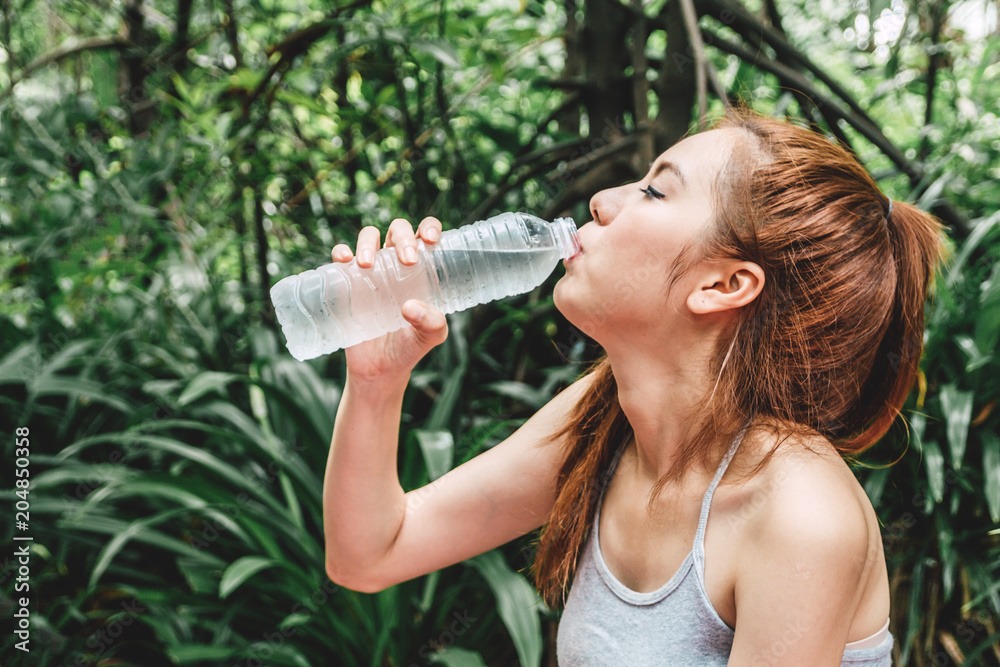 Beautiful woman drinking water on green natural fresh air.Healthy lifestyle concept Beautiful woman drinking water on green natural fresh air.Healthy lifestyle concept