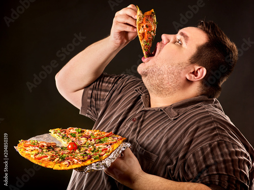Diet failure of fat man eating fast food slice pizza on plate. Close up of breakfast for hungry overweight person who spoiled healthy food. He can not give up harmful food.