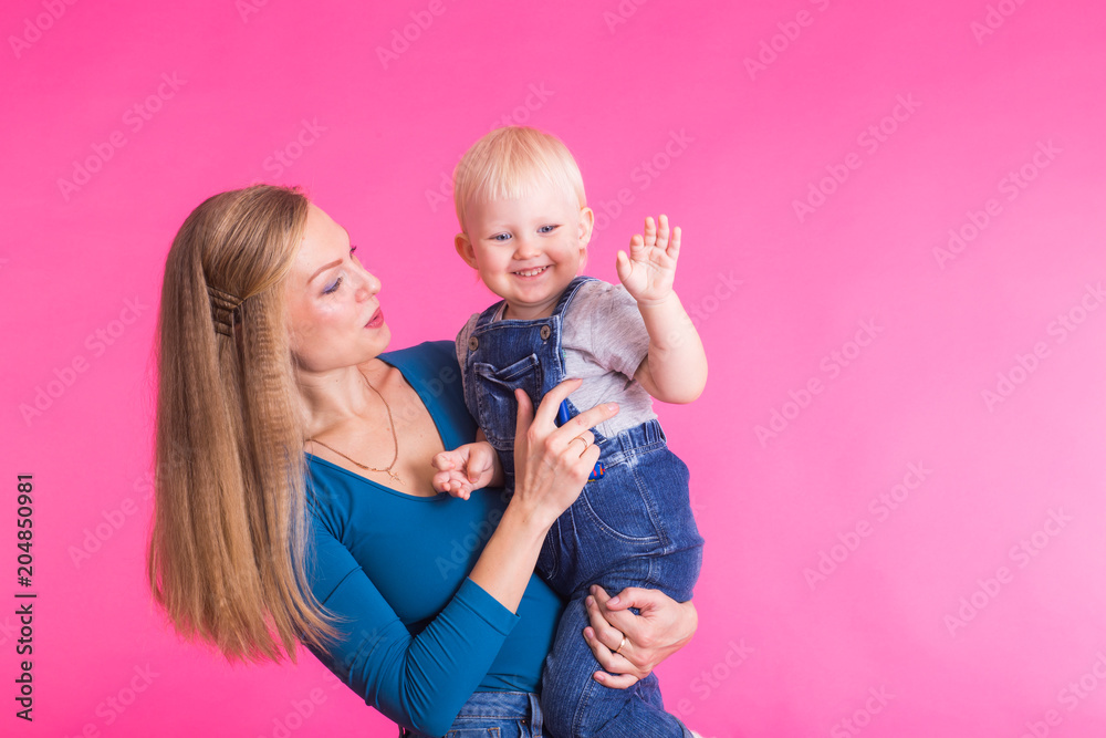 happy little girl and her mother having fun over pink background