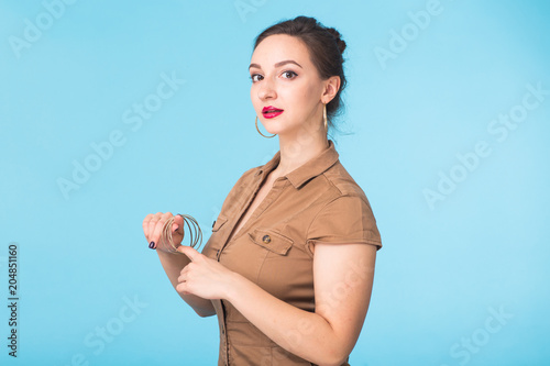 Beauty fashion female portrait. Smiling young woman on blue wall background.