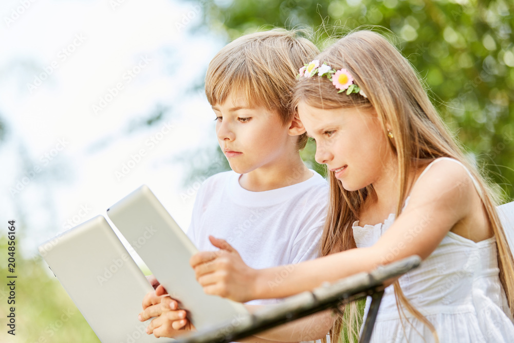 Junge und Mädchen mit Tablet im Computerkurs Junge und Mädchen mit Tablet im Computerkurs