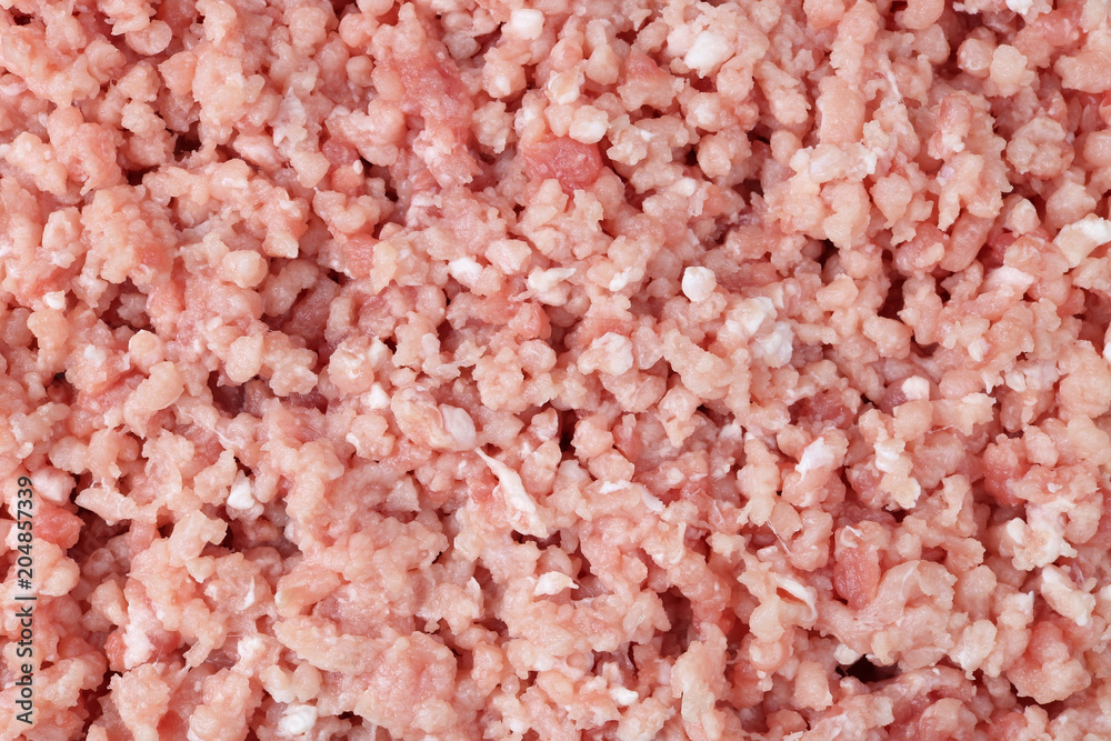Fresh pork meat is twisted on a  grinder in soft tender stuffing