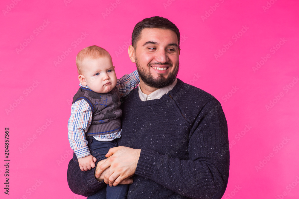 happy father with a baby son isolated on a pink background happy father with a baby son isolated on a pink background