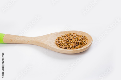 buckwheat in a spoon on white background