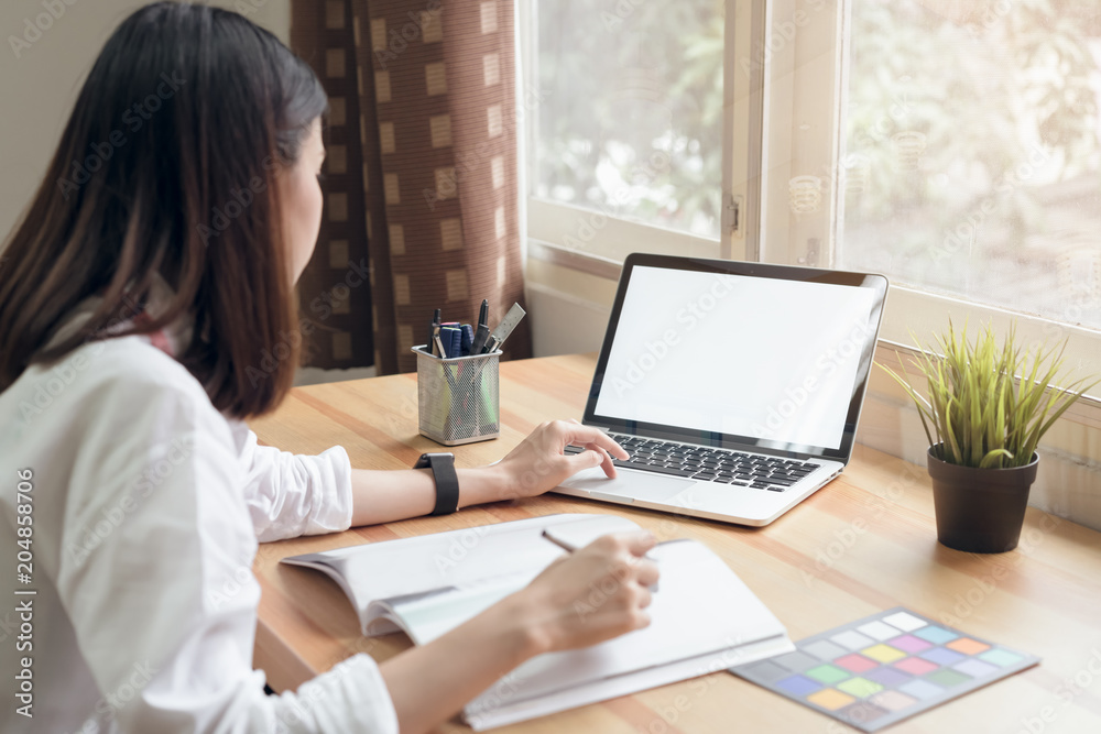 Businesswoman in office in casual shirt. Use computer for graphic designer and choose a color sample to match the publication. Businesswoman in office in casual shirt. Use computer for graphic designer and choose a color sample to match the publication.