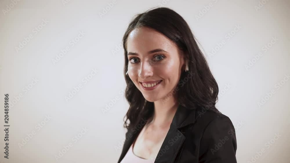 Girl puts on wireless headphones, white background.
Girl puts on wireless headphones, white background.