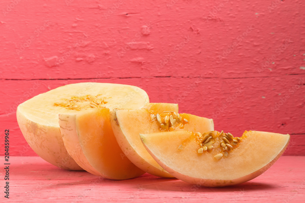 melon (sunlady) slice. half. on wood pink melon (sunlady) slice. half. on wood pink