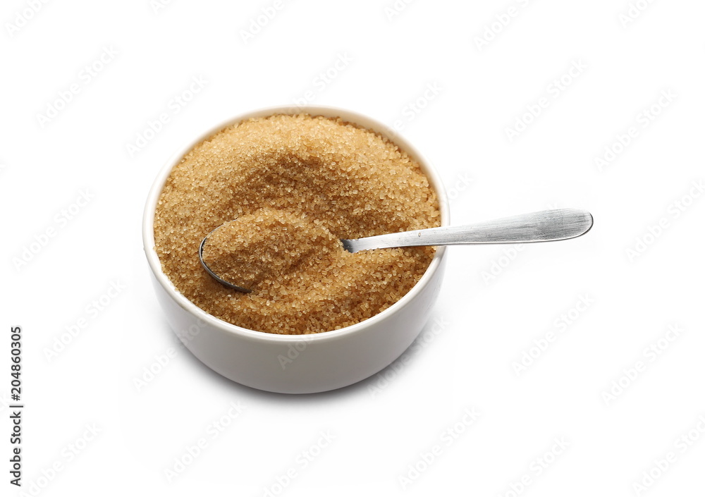 Brown cane sugar in porcelain bowl with metal spoon isolated on white background, sugarcane texture