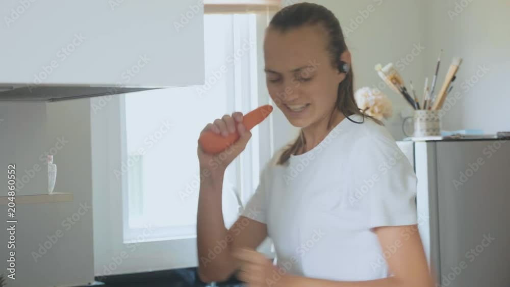Young woman dancing and singing while cooking at domestic kitchen Young woman dancing and singing while cooking at domestic kitchen