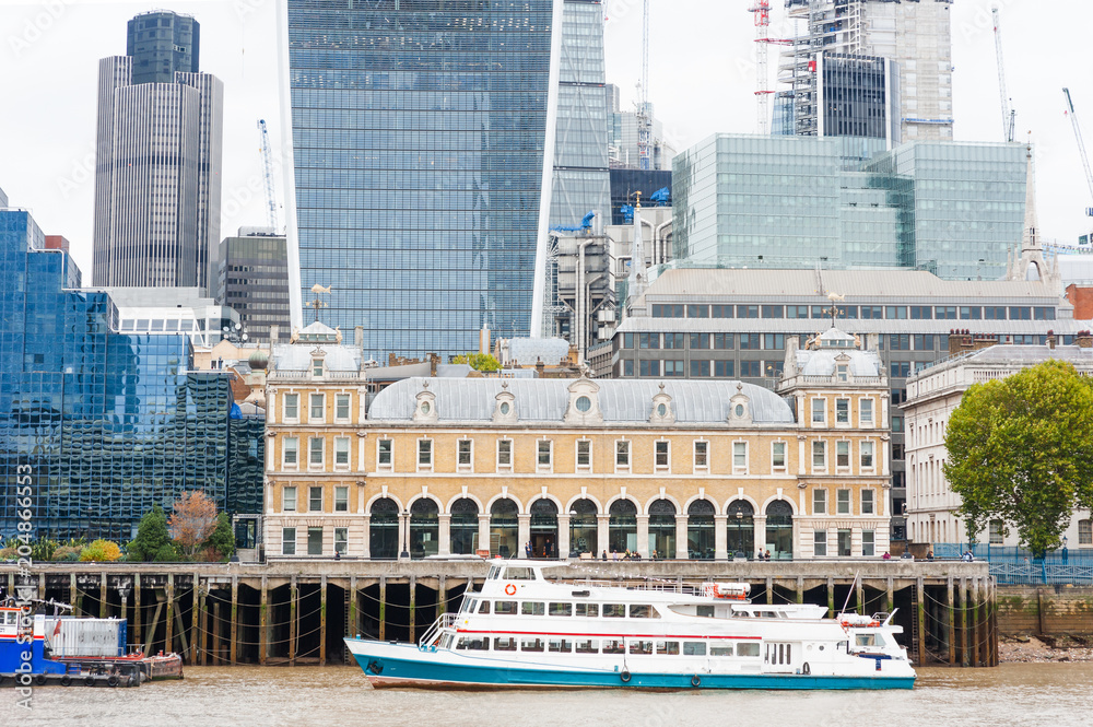 Financial district of London modern building and boat on Thames river, England