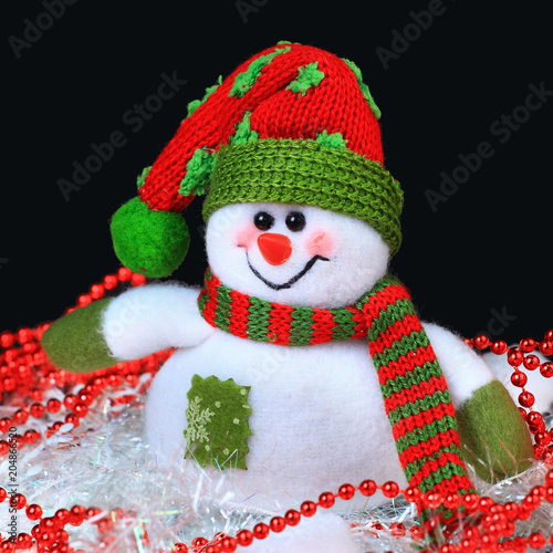 Toy decorated with a snowman, in the black background