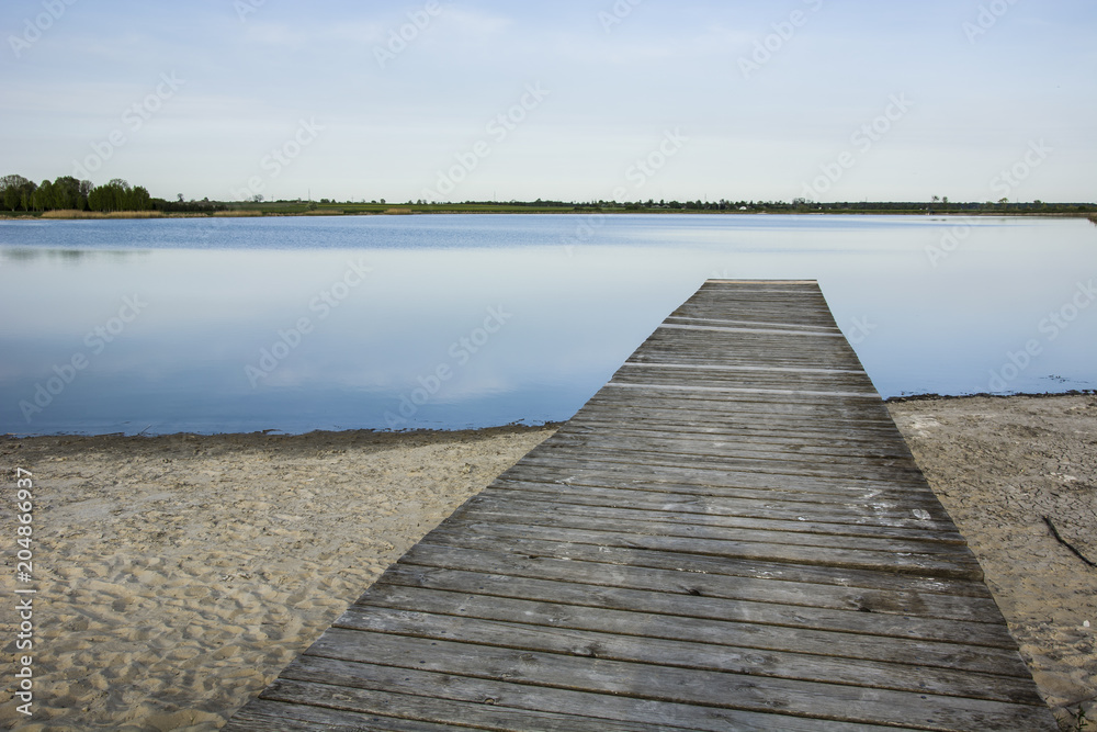 Long wooden platform on the shore of the lake