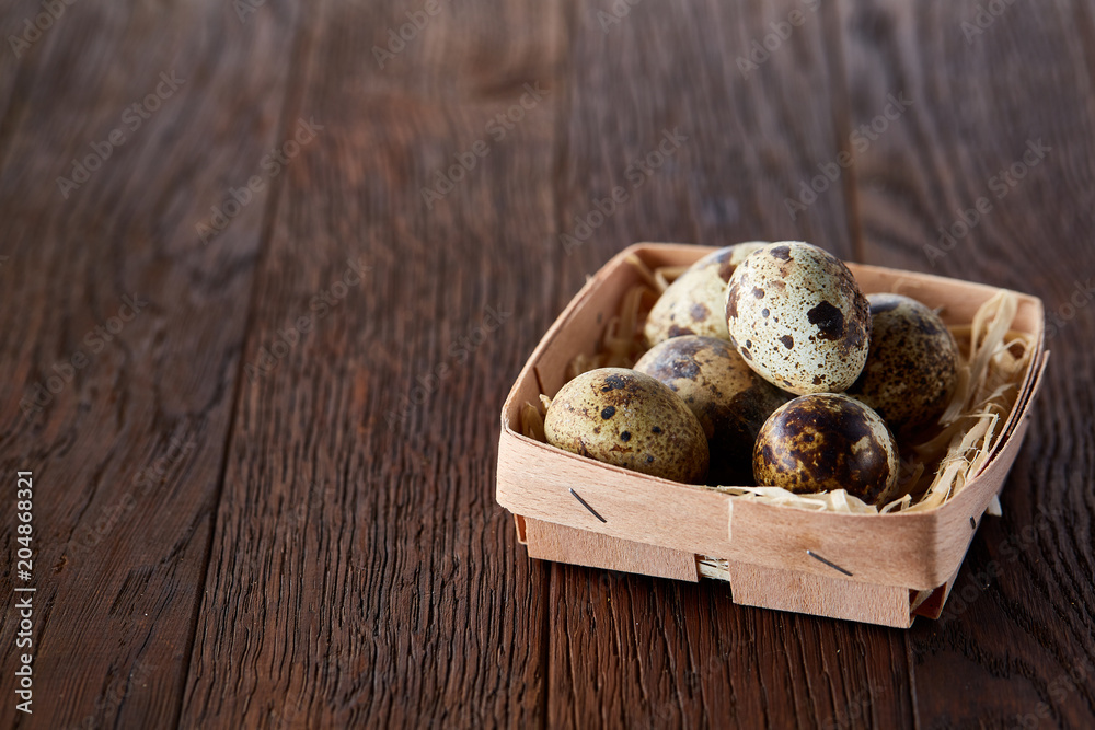 Composition of eggs quail box, eggs on a homespun napkin, boxwood on wooden background, top view Composition of eggs quail box, eggs on a homespun napkin, boxwood on wooden background, top view