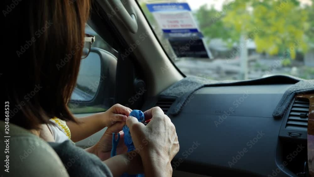 grandparent playing toy with grandchild in car travel road trip grandparent playing toy with grandchild in car travel road trip