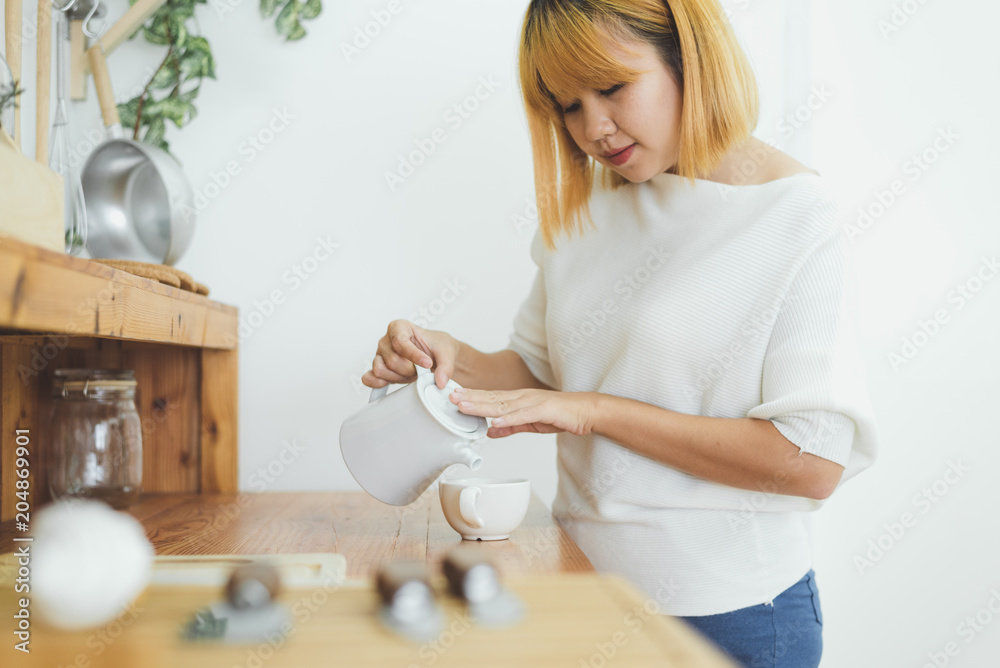 Attractive beautiful asian woman enjoying warm coffee in the kitchen at her home. Asian female wearing comfortable sweater holding a cup of coffee. lifestyle asia woman at home concept. Attractive beautiful asian woman enjoying warm coffee in the kitchen at her home. Asian female wearing comfortable sweater holding a cup of coffee. lifestyle asia woman at home concept.