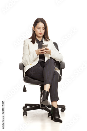pretty businesswoman texting on her smartphone on white baclground