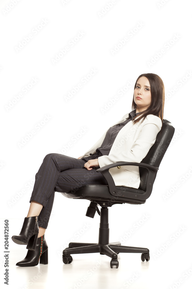 pretty businesswoman posing on armchair on white baclground pretty businesswoman posing on armchair on white baclground