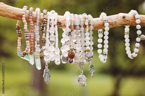 Fotomurale Natural bead bracelets hanging on natural branch