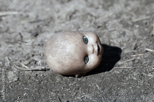 Fototapeta Naklejka Na Ścianę i Meble -  The terrible head from a doll. Horror background with head from the doll.