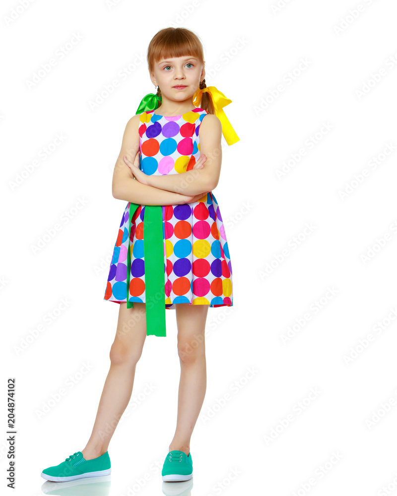 A little girl in a dress with a pattern from multi-colored circl A little girl in a dress with a pattern from multi-colored circl