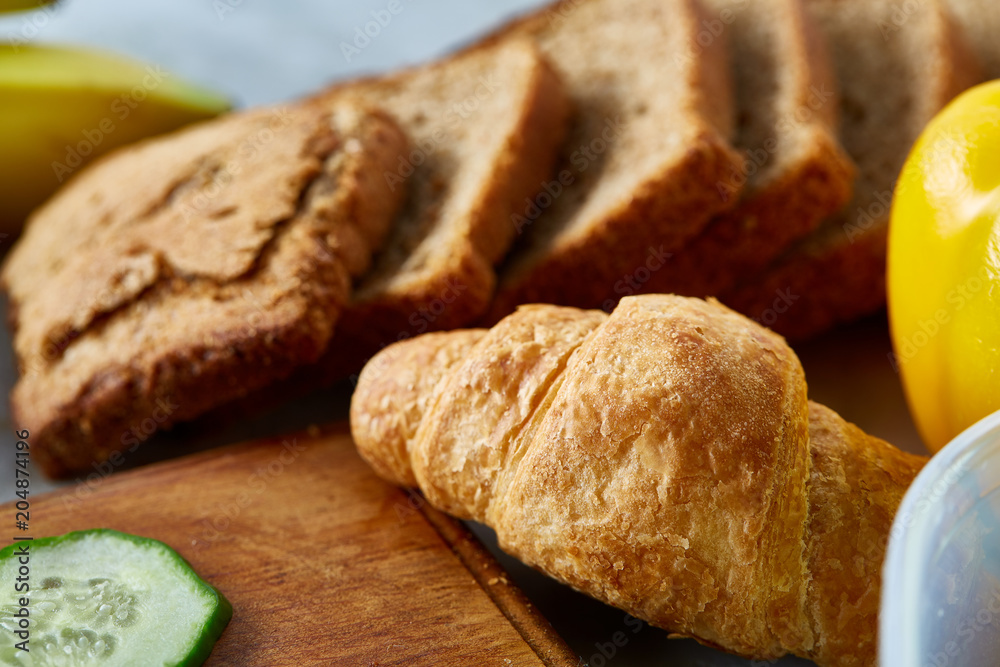 Breakfast served with croissants and fruits, top view, close-up, selective focus