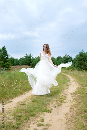 young pretty bride in white wedding dress spin around