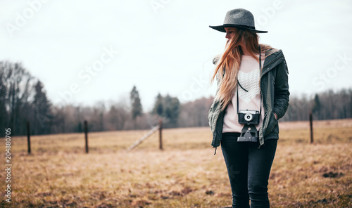 Rural scene with traveler woman in hat with vintage camera © leszekglasner