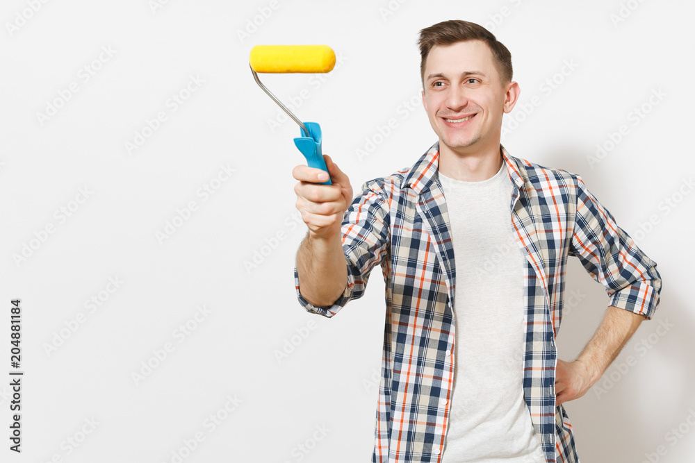 Young smiling handsome man in casual clothes pointing paint roller for wall painting on copy space isolated on white background. Instruments, tools for renovation apartment room. Repair home concept. Young smiling handsome man in casual clothes pointing paint roller for wall painting on copy space isolated on white background. Instruments, tools for renovation apartment room. Repair home concept.