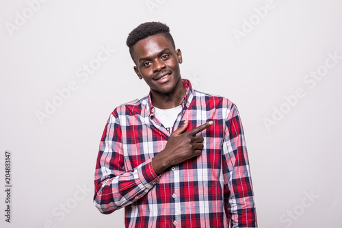 Cheerful african man pointing fingers in side over white background. Copy space.