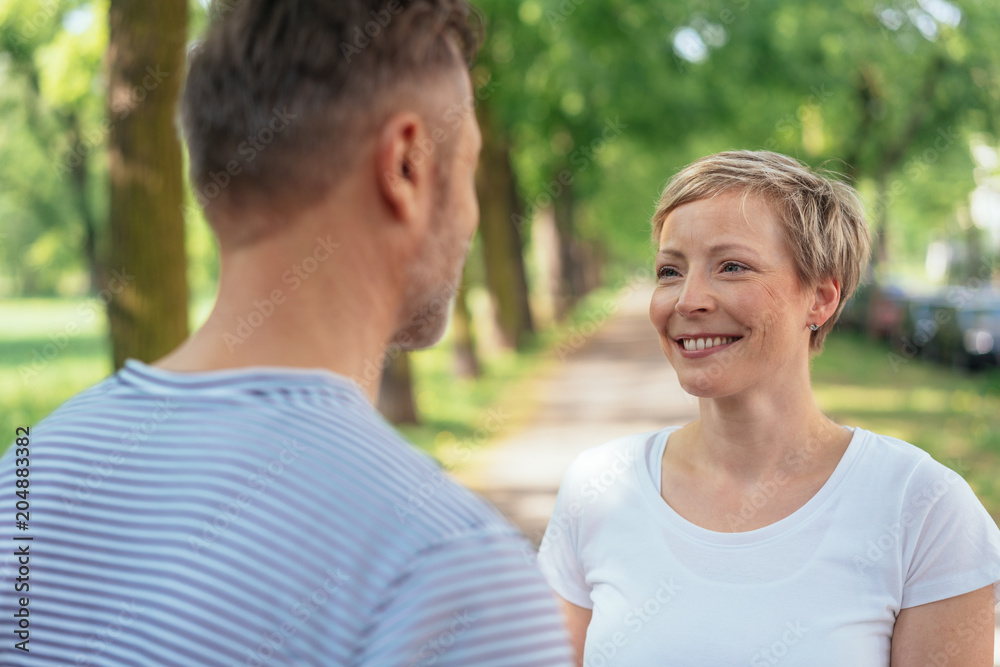 Smiling mature woman looking at man in park Smiling mature woman looking at man in park