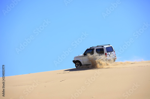 An suv was driving in the desert.