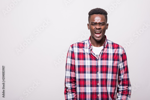 Emotional screaming young african man standing isolated over white background.