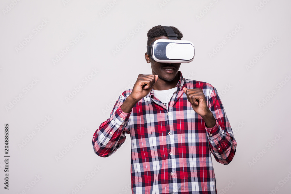 young happy and excited afro american man wearing virtual reality vr goggles enjoying video game isolated on white background in innovation and gaming box young happy and excited afro american man wearing virtual reality vr goggles enjoying video game isolated on white background in innovation and gaming box